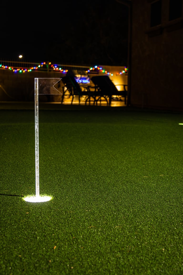 Nighttime image of a personal home putting green with illuminated holes