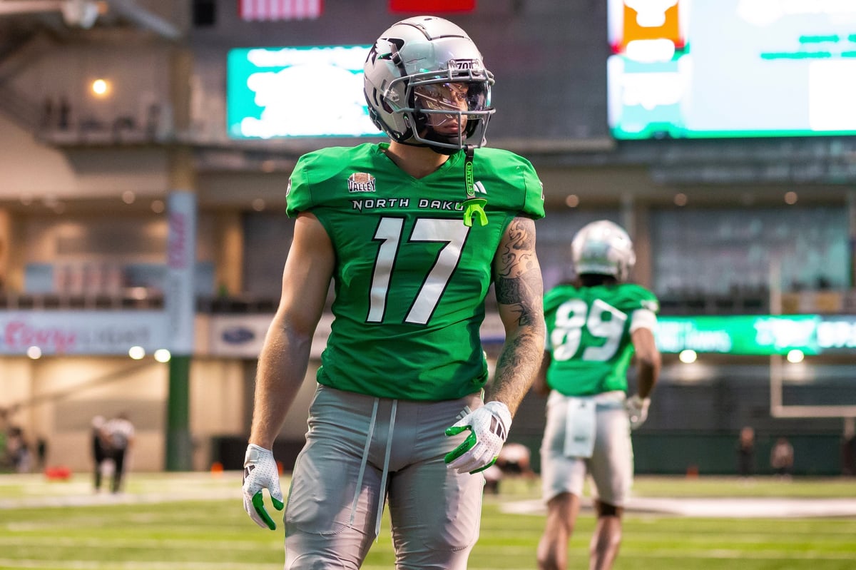 Football player wearing number 17 in green North Texas jersey walking on field during game
